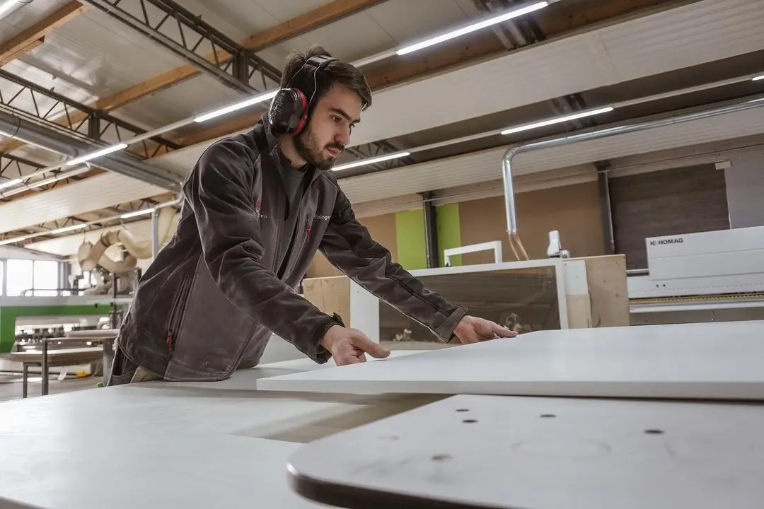 Employee at the CNC panel saw